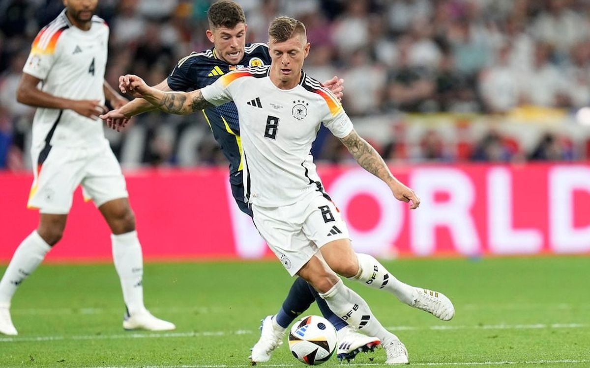 Kroos che bóng trước sự truy cản của cầu thủ Scotland